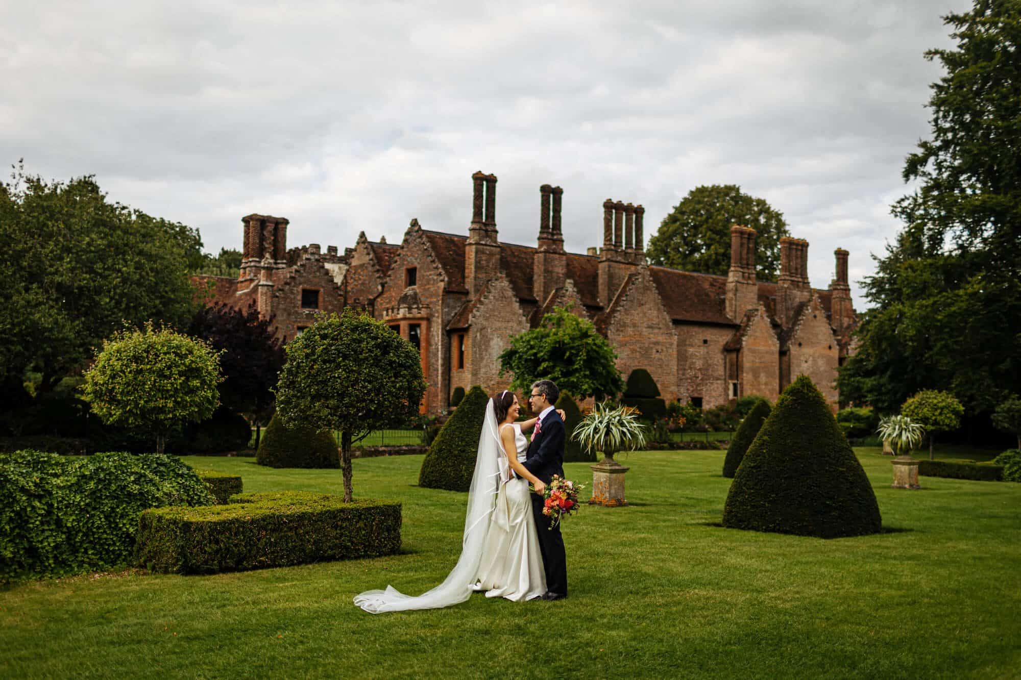 Chenies Manor House bride & groom in topiary garden